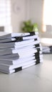 Stack of white paper documents bound with black binder clips on a white surface Royalty Free Stock Photo
