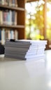 Stack of white paper documents on a table in a library with sunlight. Royalty Free Stock Photo