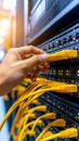 Technician connecting yellow network cables in a server room, data center environment. Royalty Free Stock Photo