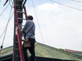 A technician troubleshoots a faulty internet fiber connection to a residence. Climbing up to check the outside junction box.