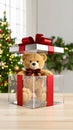 Teddy bear inside a gift box with a red bow near a Christmas tree Royalty Free Stock Photo