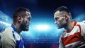 Two American football players standing closely and looking at each other with intense gaze against blurred stadium Royalty Free Stock Photo