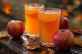 Two glasses of fresh apple cider with apples on a wooden table in the fall season. Royalty Free Stock Photo