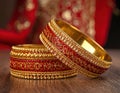 Two ornate bangles with intricate designs and sparkling details, set against a blurred background, traditional craftsmanship. Royalty Free Stock Photo