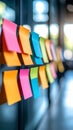 Vibrant multi colored adhesive memo flags line a partition in a blurred modern office workspace Royalty Free Stock Photo