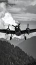 Vintage Airplane Flying Over Mountain Landscape in Black and White Royalty Free Stock Photo