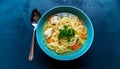 Warm healthy homemade chicken soup with noodles and vegetables in ceramic bowl on blue table.