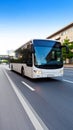 White passenger bus driving on a highway under a clear blue sky Royalty Free Stock Photo