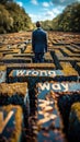 Businessman in a suit facing a Wrong Way sign at the entrance of a large complex maze, representing challenge, decision Royalty Free Stock Photo