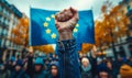 Clenched fist raised in front of the European Union flag, symbolizing solidarity, strength, unity, and the fight for Royalty Free Stock Photo