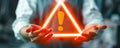 Conceptual image of a person holding a floating exclamation mark in a warning triangle, symbolizing caution, alertness, and Royalty Free Stock Photo