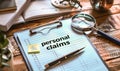 Detailed preparation for personal injury claims with notepad, pen, magnifying glass, and sticky note on a wooden desk Royalty Free Stock Photo