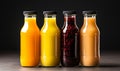 Four assorted fresh fruit juices in glass bottles with black caps on a neutral background, representing healthy dietary Royalty Free Stock Photo