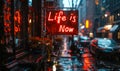 Illuminated neon sign in a rainy cityscape boldly declaring Life is Now, emphasizing the concept of living in the moment and Royalty Free Stock Photo