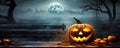One spooky halloween pumpkin Jack O Lantern with an evil face and eyes on a wooden bench table with a misty gray coastal night Royalty Free Stock Photo