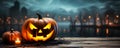 One spooky halloween pumpkin Jack O Lantern with an evil face and eyes on a wooden bench table with a misty gray coastal night Royalty Free Stock Photo