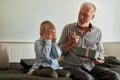 Generation. grandfather and grandson with gift box sitting on couch at home Royalty Free Stock Photo