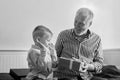 Generation. grandfather and grandson with gift box sitting on couch at home Royalty Free Stock Photo