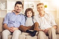 Generation portrait. Grandfather, father and son sitting on sofa