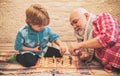 Generations. Checkmate. Chess hobbies - granddad with grandson on a playing chess.