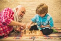 Generations. Checkmate. Chess hobbies - granddad with grandson on a playing chess.