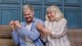 Generations family of senior mother and handsome adult son or grandson dancing together, laughing