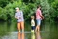 Generations men. Grandfather, father and son are fly fishing on river. Royalty Free Stock Photo