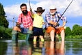 Generations men. Man with his son and father on river fishing with fishing rods. Grandpa and grandson are fly fishing on