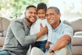 Generations of present fathers. Portrait of a mature man sitting with his son and holding his grandson at home. Royalty Free Stock Photo