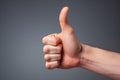 Generative AI Image Of Close Up Of Hand With Thumbs Up To Show OK Or Approval On Grey Background