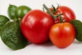 Red tomatoes with green leaves on a white background. Close-up. Healthy food concept. Generative AI Royalty Free Stock Photo