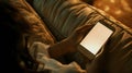 Generative AI Back view close up of a woman hand using a smart phone with blank screen lying on a couch at home bu Royalty Free Stock Photo