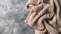 Generative AI Beige knitted blanket on gray concrete background with copy spaceAutumn winter  conceptFlat lay top Royalty Free Stock Photo