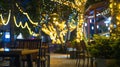 Generative AI Blur image of outdoor park restaurant with light up decoration on trees at night business concept. Royalty Free Stock Photo