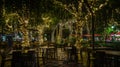 Generative AI Blur image of outdoor park restaurant with light up decoration on trees at night business concept. Royalty Free Stock Photo