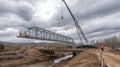 Generative AI Bridge Construction Featuring a Crane Lifting Steel Structure Over River Under an Overcast Sky busin Royalty Free Stock Photo