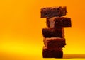 Generative AI Composition of little stack of tasty sweet brownie yellow and orange background business concept.