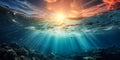Dramatic underwater seascape with sunbeams piercing through the ocean surface amid rolling waves and a vibrant sunset sky