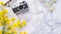 Generative AI Flat lay of white marble table with stationery glasses yellow flowers and photo camera Top view with