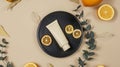 Generative AI Golden cream tube and dry orange slices eucalyptus leaves on black plate on beige background Top vie