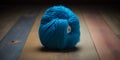 Generative AI illustration of blue woolen yarn ball placed on colorful timber floor Royalty Free Stock Photo