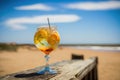 Generative AI. Illustration of a glass with cool cocktail on wooden table on the beach. Sea vacation, bar on a tropical beach Royalty Free Stock Photo