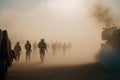 AI generated silhouettes of army soldiers attacking in smoke against sunset marines team in action Royalty Free Stock Photo