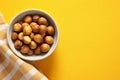 Generative AI Image of Hazelnuts in a Bowl with Blank Space on Yellow Background