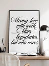 Contemporary home office setup featuring elegant black framed wall art with stylized text against white background complemented by