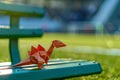 Generative AI Image of Origami Paper Craft Forming a Dinosaur Animal on a Bench