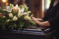 Generative AI Image Showing Close Up Of Woman Standing Next To Funeral Coffin Or Casket With Wreath Of Lilies On Top Royalty Free Stock Photo