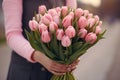 Generative AI International Women's Day. A woman holds a bouquet of pink tulips. Close-up view. Happy Mother's