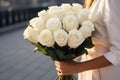 Generative AI International Women& x27;s Day. A woman holds a lush bouquet of white roses. Close-up view. Happy