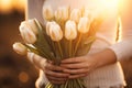 Generative AI International Women& x27;s Day. A woman in a white dress holds a lush bouquet of white tulips at sunset